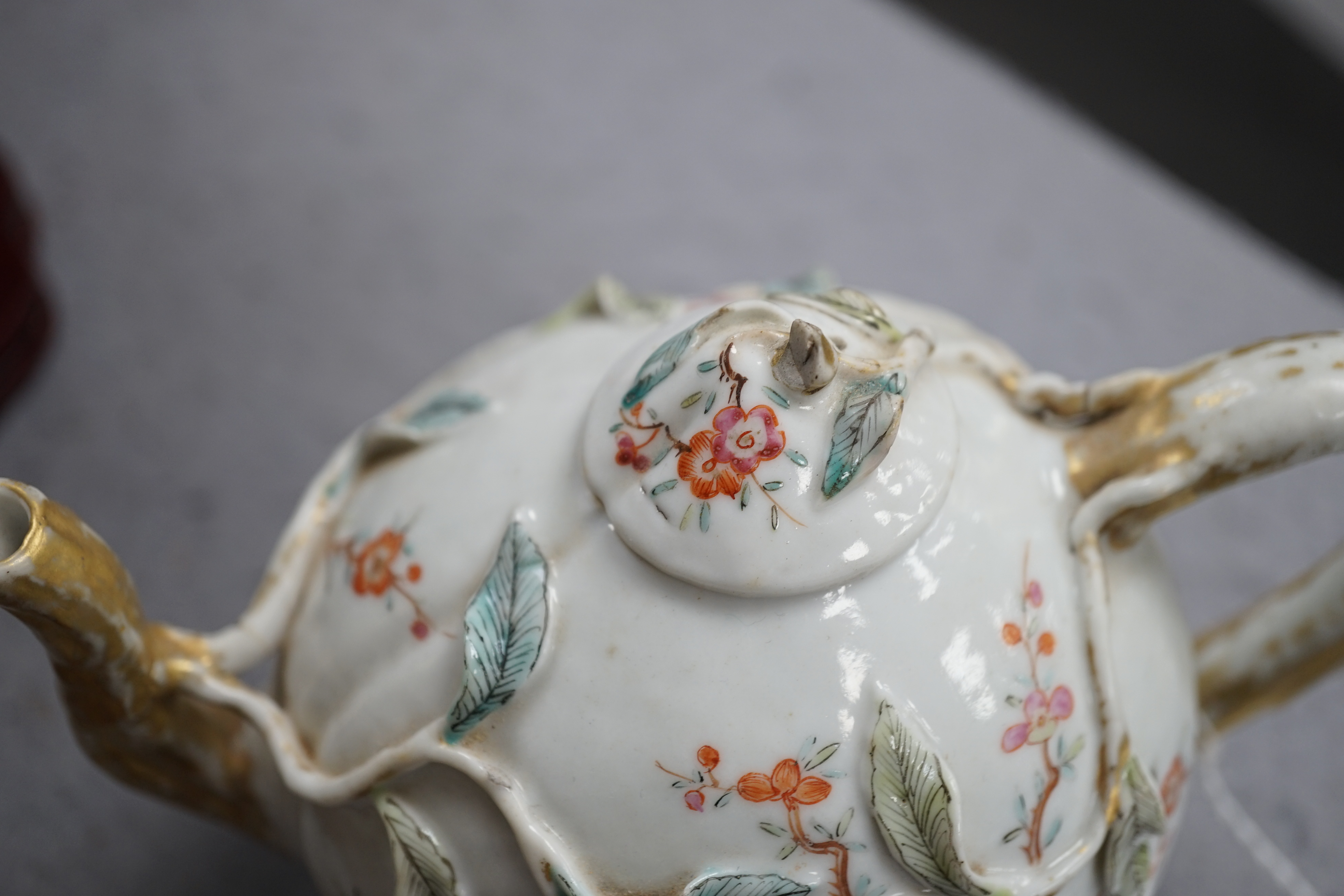 A Chinese enamelled porcelain peach-shaped teapot, Qianlong period (1736-95), wear to gilding